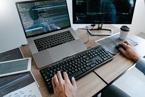 Vue sur une personne en train d'utiliser un ordinateur sur lequel figure des données. View on a person using a computer with data on it. 